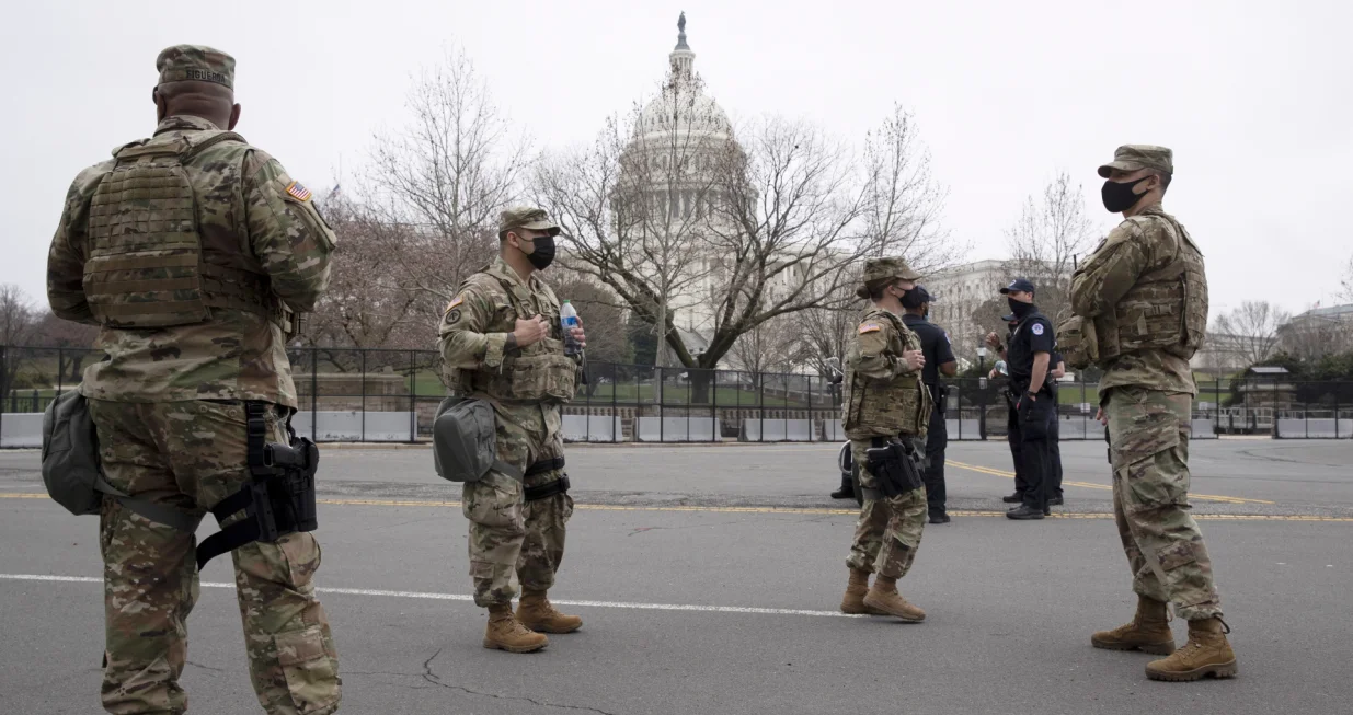 epa09097145 Members of the US National Guard (Front), with Capitol Police officers (Behind), stand outside the inner perimeter security fence on the West Front of the US Capitol in Washington, DC, USA, 25 March 2021. The Capitol Reflecting Pool, just west of the US Capitol Building, became available for the public to visit this week for the first time since the 06 January mob riot attack on the Capitol. An inner perimeter security fence around the Capitol remains in place. EPA/MICHAEL REYNOLDS/Michael Reynolds