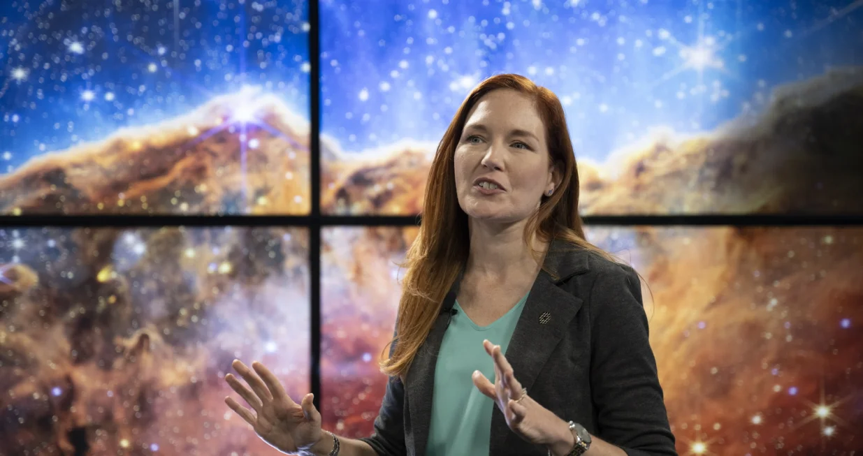epa10067482 NASA James Webb Space Telescope Deputy Project Scientist for Communications Amber Straughn speaks about the infrared image of the star-forming region called NGC 3324 in the Carina Nebula as it is shown on a screen during a broadcast releasing the telescope's first full-color images, at the NASA's Goddard Space Flight Center in Greenbelt, Maryland, USA, 12 July 2022. The first full-color images and spectroscopic data from the James Webb Space Telescope, a partnership with ESA (European Space Agency) and the Canadian Space Agency (CSA), are a demonstration of the power of Webb as the telescope begins its science mission to unfold the infrared universe. EPA/BILL INGALLS/NASA HANDOUT HANDOUT EDITORIAL USE ONLY/NO SALES/Bill Ingalls/Nasa Handout