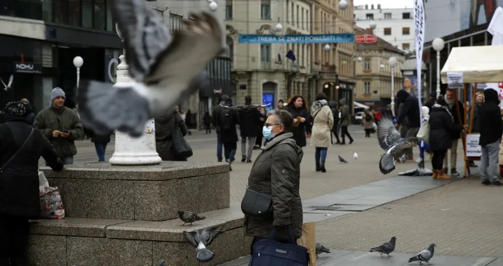 epa09642892 A person wears a face mask while walking around Zagreb, Croatia, 15 December 2021.Croatian authorities have confirmed at least eight people infected with the coronavirus Omicron variant. EPA/ANTONIO BAT/Antonio Bat