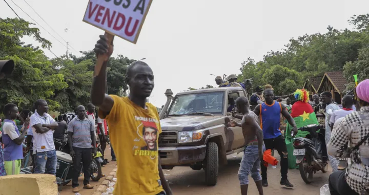 epa10219957 Residents cheer a military vehicle as it moves through the streets during a rally in support of the coup in Ouagadougou, Burkina Faso, 02 October 2022. Thousands of residents came out in support of the coup and protested against France and called for more involvement from Russia. On 01 October, gunshots were heard and the French embassy was set on fire a day after a coup in Ouagadougou. Burkina Faso military Colonel Ibrahim Traore announced on state television 30 September that he had seized power from Lt-Col Paul-Henri Damiba in the coup and alleged Damiba is plotting a counter-attack. In January 2022 Lt-Col Paul-Henri Damiba, ousted President Roch Kabore through a coup. EPA/ASSANE OUEDRAOGO/Assane Ouedraogo