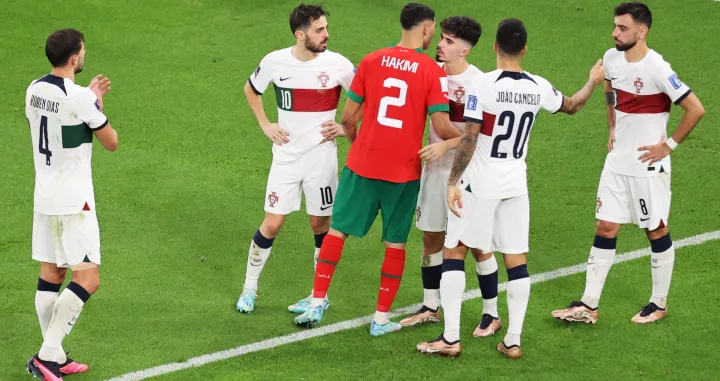 epa10359702 Achraf Hakimi of Morocco (C) embraces his Paris Saint Germain (PSG) teammate Vitinha of Portugal after the FIFA World Cup 2022 quarter final soccer match between Morocco and Portugal at Al Thumama Stadium in Doha, Qatar, 10 December 2022. EPA/Abedin Taherkenareh