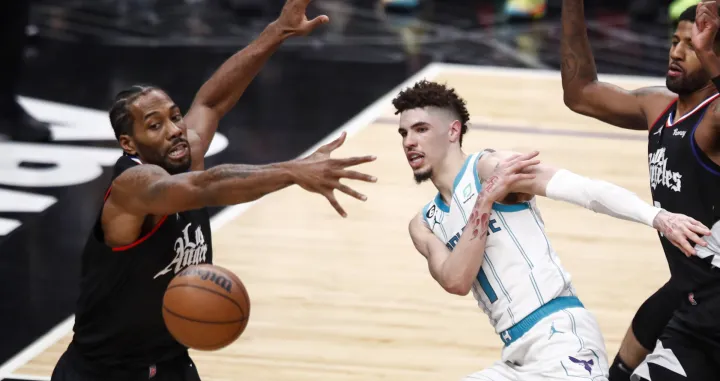 epa10376127 Charlotte Hornets guard LaMelo Ball (R) passes to a teammate while being guarded by LA Clippers forward Kawhi Leonard (L), during the third quarter of the NBA basketball game between the Los Angeles Clippers and the Charlotte Hornets at Crypto.com Arena in Los Angeles, California, USA, 21 December 2022. EPA/CAROLINE BREHMAN SHUTTERSTOCK OUT