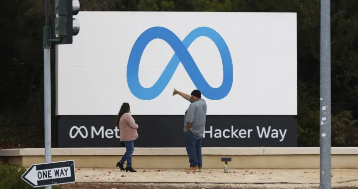 epa10295086 People stand in front of a Meta sign at the headquarters of Meta Platforms Inc., formerly named Facebook, Inc., in Menlo Park, California, USA, 08 November 2022. Chief Executive Mark Zuckerberg told company executives that Meta will begin laying off employees on 09 November. EPA/JOHN G. MABANGLO/John G. Mabanglo