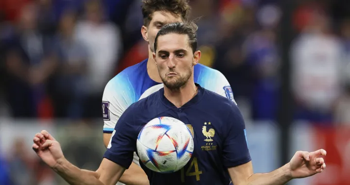 epa10360097 Adrien Rabiot (front) of France in action against John Stones (back) of England during the FIFA World Cup 2022 quarter final soccer match between England and France at Al Bayt Stadium in Al Khor, Qatar, 10 December 2022. EPA/Ronald Wittek