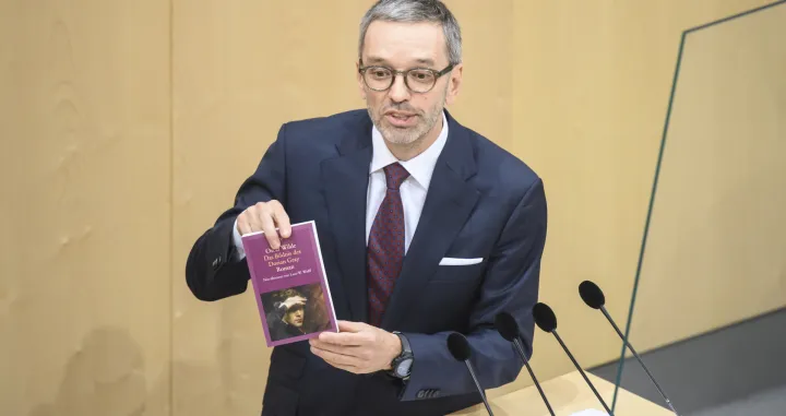 epa09519805 Herbert Kickl, leader of the right-wing Austrian Freedom Party (FPOe), displays a book of Oscar Wild as he delivers a speech during a special session of the Austrian parliament at the temporary parliament building at the Hofburg Palace in Vienna, Austria, 12 October 2021. EPA/CHRISTIAN BRUNA/Christian Bruna