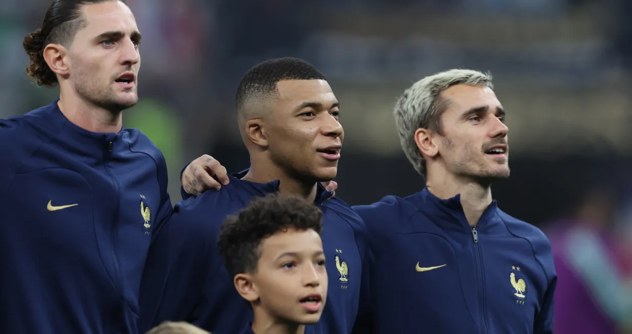 epa10372180 Kylian Mbappe (C) and Antoine Griezmann (R) of France during the ntional anthem prior to the FIFA World Cup 2022 Final between Argentina and France at Lusail stadium, Lusail, Qatar, 18 December 2022. EPA/Tolga Bozoglu