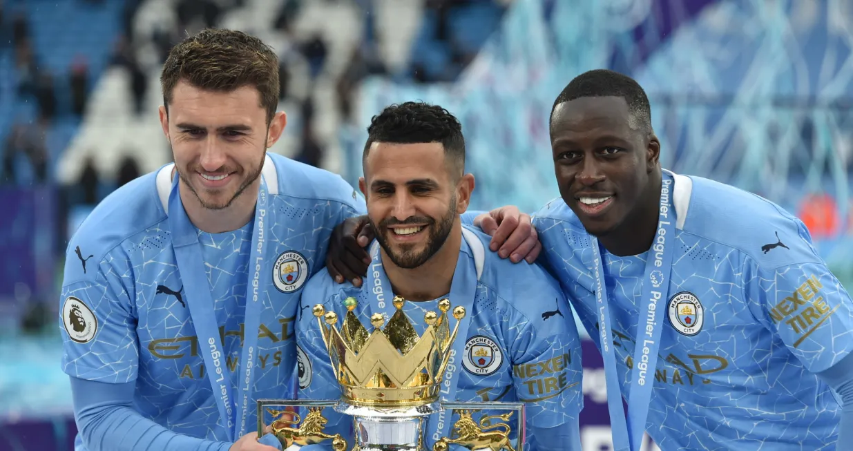 epa09224131 Aymeric Laporte (L) Riyad Mahrez (C) and Benjamin Mendy (R) of Manchester City celebrate during the Premier League trophy presentation after the English Premier League soccer match between Manchester City and Everton FC in Manchester, Britain, 23 May 2021. EPA/Peter Powell/POOL EDITORIAL USE ONLY. No use with unauthorized audio, video, data, fixture lists, club/league logos or 'live' services. Online in-match use limited to 120 images, no video emulation. No use in betting, games or single club/league/player publications.