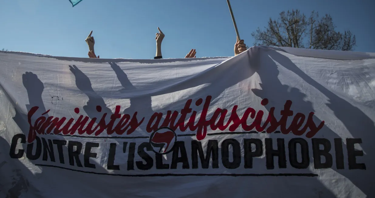 epa09059725 A group of feminist activists against Islamophobia holds a banner reading 'Anti-Fascists Feminist against Islamophobia', as they disrupt a rally on the eve of the International Women's Day at Republique square in Paris, France, 07 March 2021. International Women's Day (IWD) is a global day that celebrates women's achievements socially, economically, culturally and politically and also an invitation for all elements of society to accelerate gender equality. EPA/CHRISTOPHE PETIT TESSON/Christophe Petit Tesson