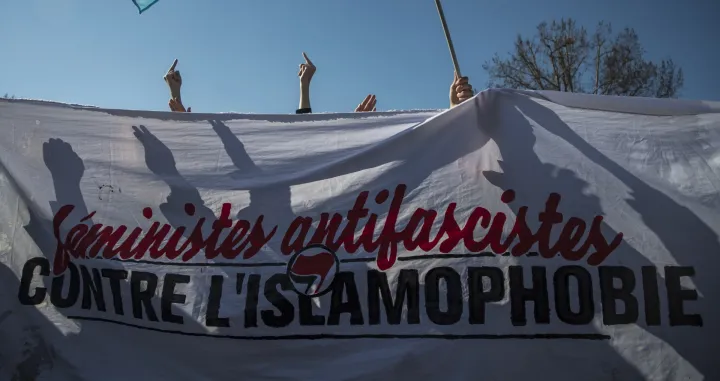 epa09059725 A group of feminist activists against Islamophobia holds a banner reading 'Anti-Fascists Feminist against Islamophobia', as they disrupt a rally on the eve of the International Women's Day at Republique square in Paris, France, 07 March 2021. International Women's Day (IWD) is a global day that celebrates women's achievements socially, economically, culturally and politically and also an invitation for all elements of society to accelerate gender equality. EPA/CHRISTOPHE PETIT TESSON/Christophe Petit Tesson