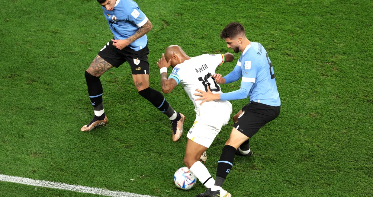 epa10344296 Rodrigo Bentancur (R) and Mathias Olivera of Uruguay in action against Andre Ayew (C) of Ghana during the FIFA World Cup 2022 group H soccer match between Ghana and Uruguay at Al Janoub Stadium in Al Wakrah, Qatar, 02 December 2022. EPA/Tolga Bozoglu