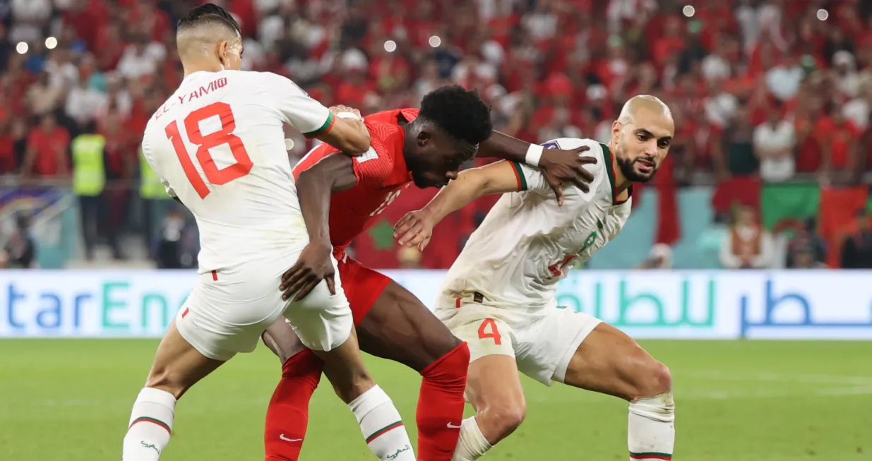 epa10342030 Alphonso Davies (C) of Canada in action against Sofyan Amrabat (R) of Morocco during the FIFA World Cup 2022 group F soccer match between Canada and Morocco at Al Thumama Stadium in Doha, Qatar, 01 December 2022. EPA/Mohamed Messara