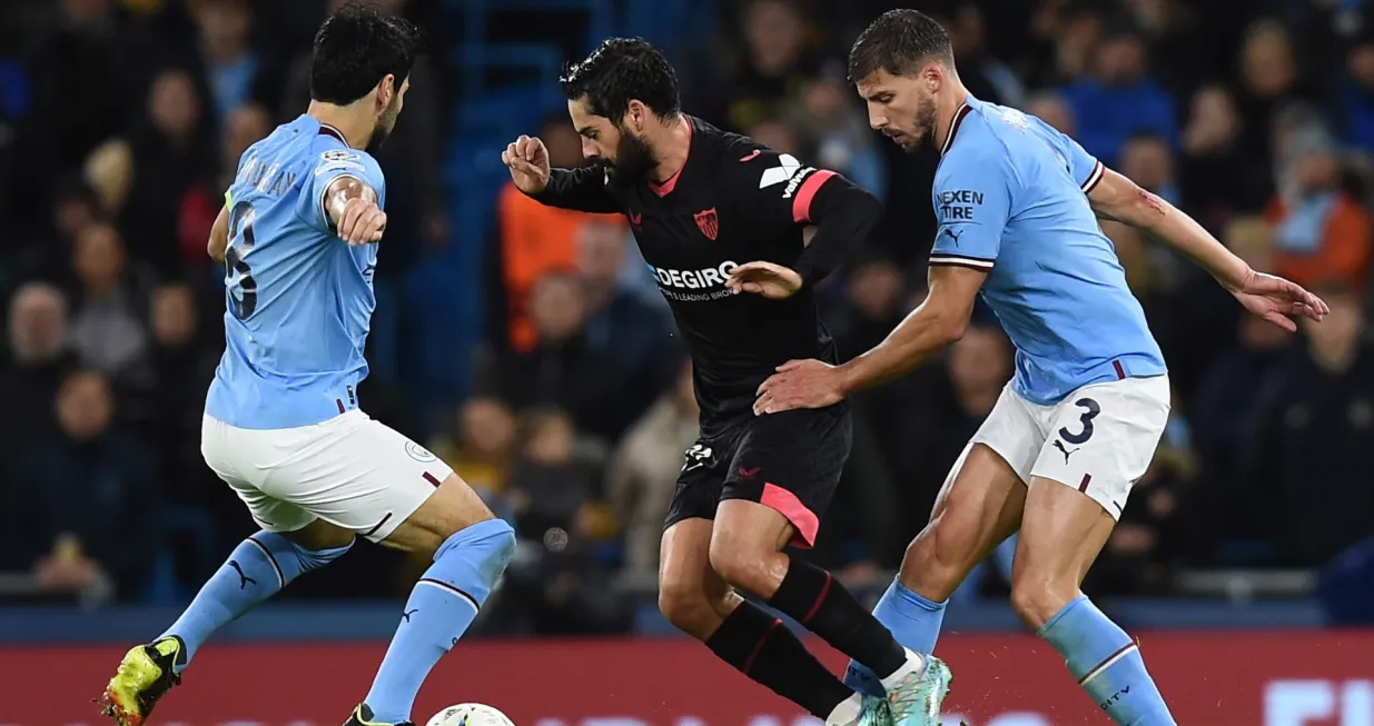 epa10282319 Sevilla's Isco (C) in action against Manchester City's Ilkay Gundogan (L) and Ruben Dias (R) during the UEFA Champions League group G soccer match between Manchester City and Sevilla FC in Manchester, Britain, 02 November 2022. EPA/PETER POWELL