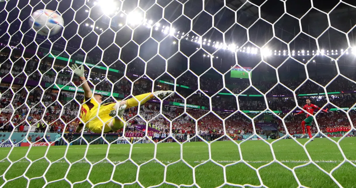 epa10352414 Hakim Ziyech of Morocco converts against goalkeeper Unai Simon of Spain during the penalty shoot-out of the FIFA World Cup 2022 round of 16 soccer match between Morocco and Spain at Education City Stadium in Doha, Qatar, 06 December 2022. EPA/TOLGA BOZOGLU