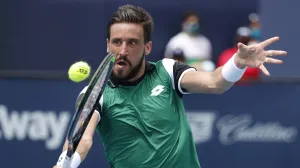 epa09102167 Damir Dzumhur of Bosnia in action against Stefanos Tsitsipas of Greece during their Men's singles match at the Miami Open tennis tournament in Miami Gardens, Florida, USA, 27 March 2021. EPA/RHONA WISE