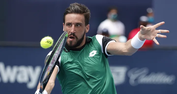 epa09102167 Damir Dzumhur of Bosnia in action against Stefanos Tsitsipas of Greece during their Men's singles match at the Miami Open tennis tournament in Miami Gardens, Florida, USA, 27 March 2021. EPA/RHONA WISE