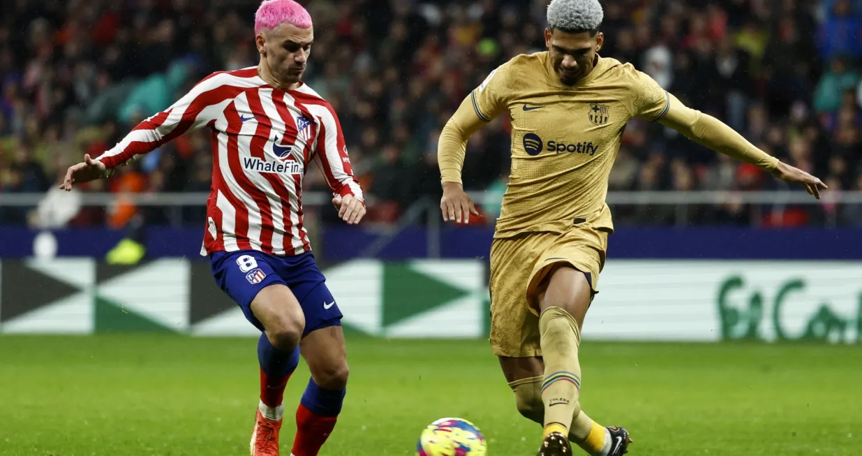 epa10396353 Atletico's striker Antoine Griezmann (L) vies for the ball against FC Barcelona's Uruguayan defender Ronald Araujo (R) during the Spanish LaLiga soccer match between Atletico de Madrid and FC Barcelona at Civitas Metropolitano stadium in Madrid, Spain, 08 January 2023. EPA/Rodrigo Jimenez