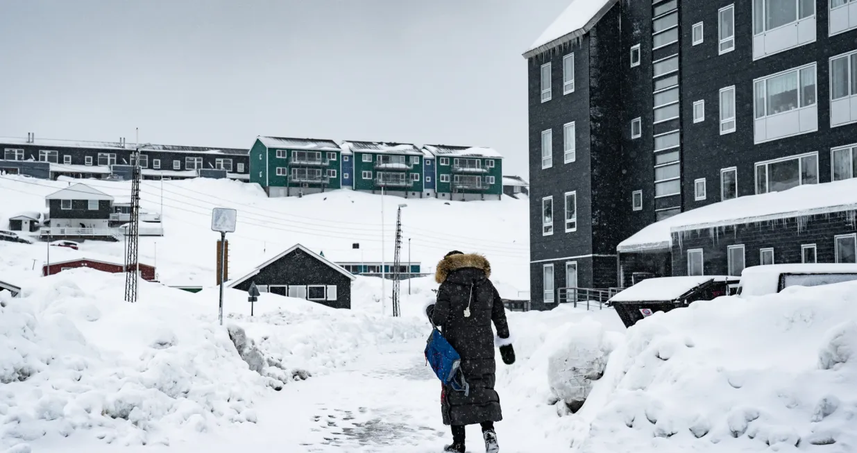 epa09112194 Woman walks the snow-covered street in Nuuk, Greenland, 02 April 2021. The Danish autonomous territory Greenland will hold parliamentary elections on 06 April 2021. EPA/EMIL HELMS DENMARK OUT/Emil Helms