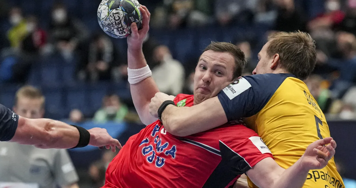 epa09709168 Sander Sagosen of Norway (L) in action against Max Darj of Sweden (R) during the Men's European Handball Championship main round match between Sweden and Norway in Bratislava, Slovakia, 25 January 2022. EPA/MARTIN DIVISEK