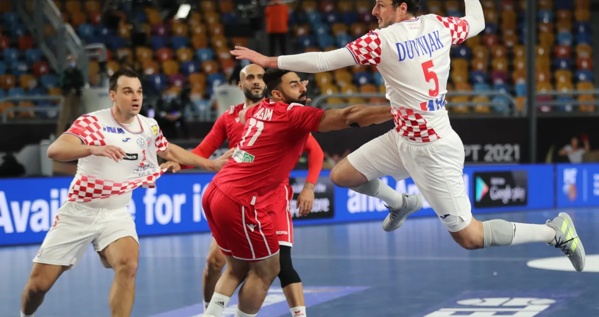 epa08956014 Croatia's Domagoj Duvnjak (R) in action against Bahrain's Jasim Alsalatna (C) during the match between Croatia and Bahrain at the 27th Men's Handball World Championship in Cairo, Egypt, 21 January 2021. EPA/Mohamed Abd El Ghany/POOL