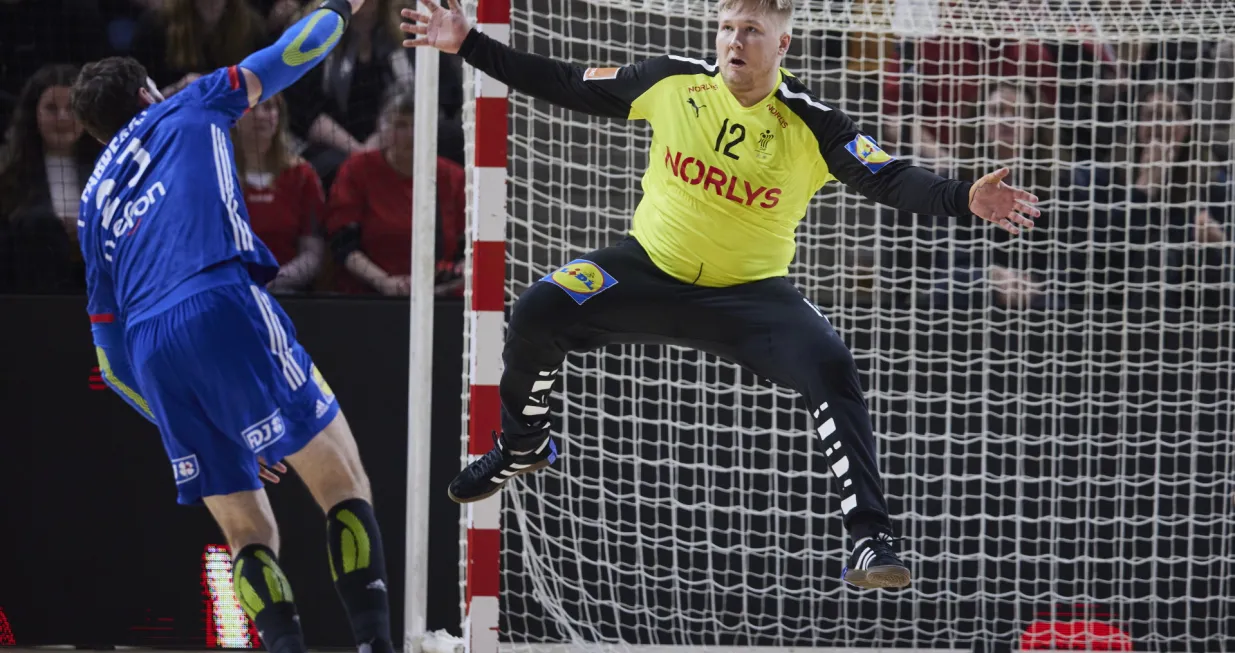 epa09838714 France' Ludovic Fabregas (L) in action against Denmark's goalkeeper Emil Nielsen during the Golden League men's handball match between Denmark and France, in Aarhus, Denmark, 20 March 2022. EPA/Mikkel Berg Pedersen DENMARK OUT