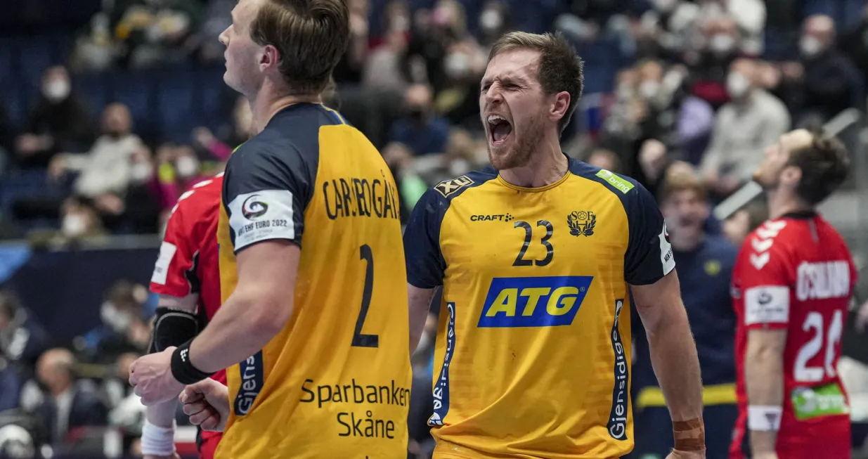 epa09709221 Jonathan Carlsbogard (L) and Albin Lagergren (R) of Sweden celebrate winning the Men's European Handball Championship main round match between Sweden and Norway in Bratislava, Slovakia, 25 January 2022. EPA/MARTIN DIVISEK