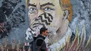 epa08813894 A Palestinian man walks past an anti- USA President Donald Trump mural in the street of Gaza City, 11 November 2020. EPA/MOHAMMED SABER/Mohammed Saber