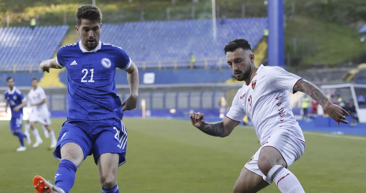 epa09243514 Sead Haksabanovic (R) of Montenegro in action against Damir Sadikovic (L) of Bosnia and Herzegovina during the International Friendly soccer match between Bosnia and Herzegovina and Montenegro in Sarajevo, Bosnia and Herzegovina, 02 June 2021. EPA/FEHIM DEMIR