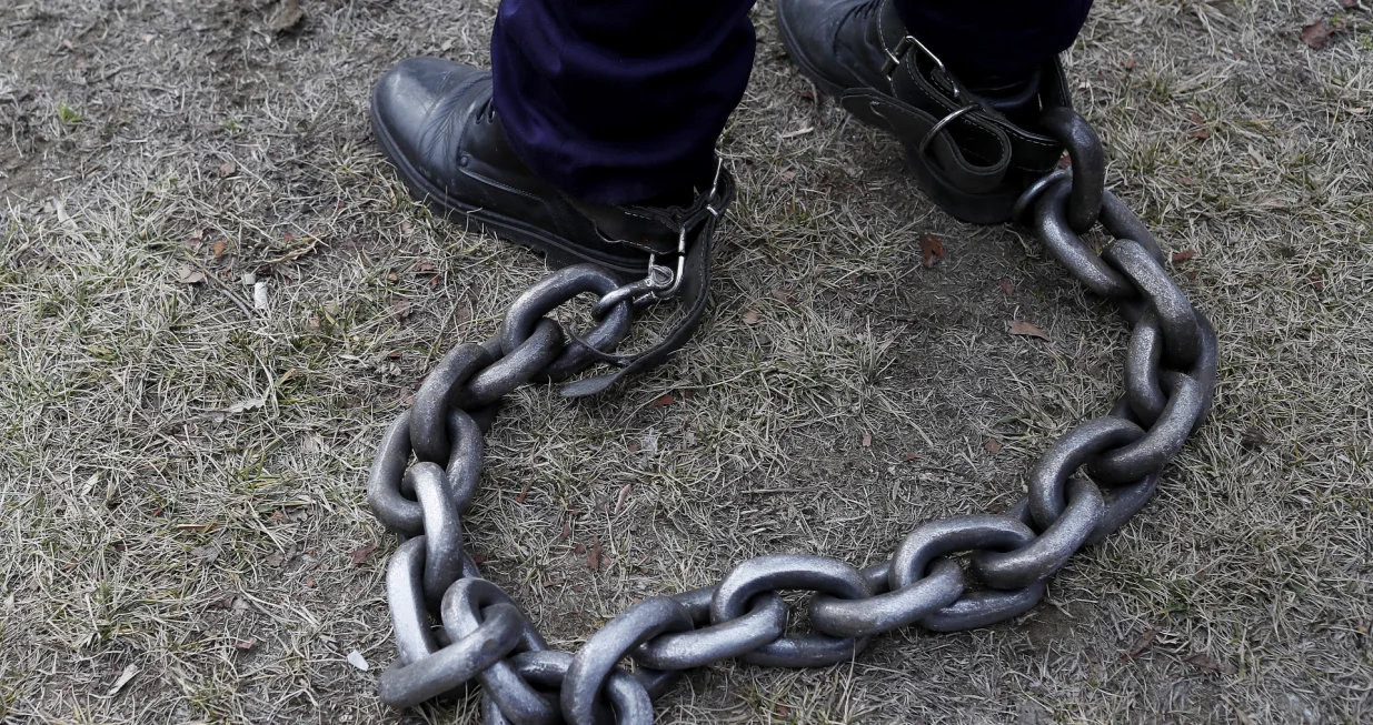 epaselect epa09723002 A Romanian policeman has his legs tied with a heavy chain during a rally held in front of the Romanian Parliament headquarters in Bucharest, Romania, 02 February 2022. About 1,500 policemen, prison guards and retired defense system employees from all over the country, gathered by fourteen trade union organizations, including Europol, joined a protest demanding the government to comply with the law on the remuneration of staff paid from public funds. Protesters marched through the center of Romania's capital asking for their risk supplementary payment and full pensions, demanding better working conditions and the employment of additional staff for solving specific tasks in a timely manner. EPA/ROBERT GHEMENT/Robert Ghement