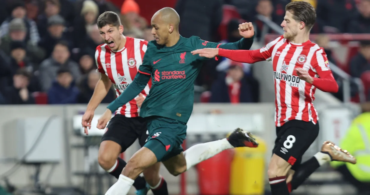 epa10386657 Fabinho of Liverpool (C) in action against Vitaly Janelt (L) and Mathias Jensen (R) of Brentford during the English Premier League soccer match between Brentford FC and Liverpool FC in Brentford, Britain, 02 January 2023. EPA/Kieran Galvin EDITORIAL USE ONLY. No use with unauthorized audio, video, data, fixture lists, club/league logos or 'live' services. Online in-match use limited to 120 images, no video emulation. No use in betting, games or single club/league/player publications