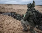 A Lithuanian instructor assists two Ukrainian soldiers standing in a trench during an eight-week training course./Nato