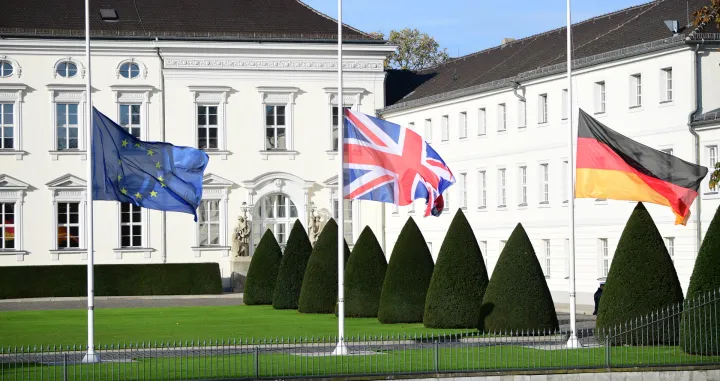 epa08821611 National flags of Great Britain (C), Germany (R), and the European Union are set half mast during a visit of the British royal couple to Bellevue palace in Berlin, Germany, 15 November 2020. The British royal couple are scheduled to attend events 15 November on Germany's National Day of Mourning that commemorates victims of war and fascism, during which Prince Charles is to give a speech at the Bundestag. EPA/CLEMENS BILAN/Clemens Bilan