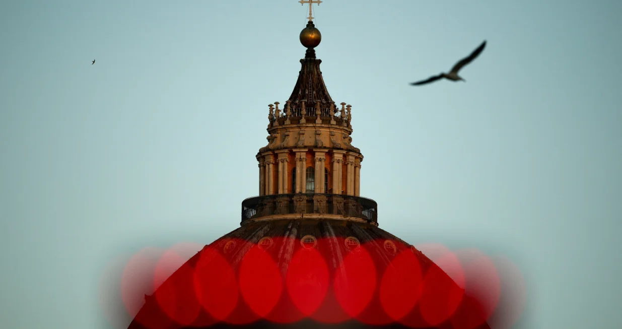 A bird flies past the dome of St. Peter's Basilica on the first day of the conclave to elect the next pope, near the Vatican, in Rome, Italy, May 7, 2025. REUTERS/Guglielmo Mangiapane TPX IMAGES OF THE DAY/Guglielmo Mangiapane