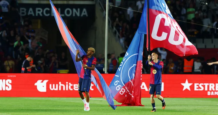 Soccer Football - LaLiga - FC Barcelona v Villarreal - Estadi Olimpic Lluis Companys, Barcelona, Spain - May 18, 2025 FC Barcelona's Marc Casado and FC Barcelona's Lamine Yamal celebrate with flags after winning LaLiga REUTERS/Albert Gea