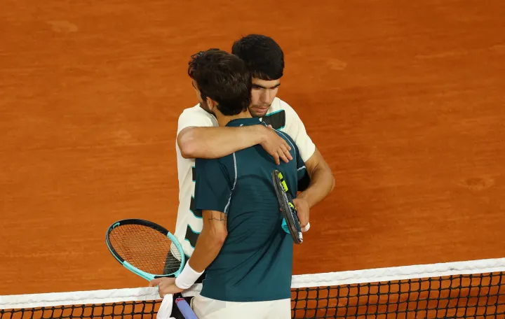 Tennis - French Open - Roland Garros, Paris, France - June 6, 2025 Italy's Lorenzo Musetti hugs Spain's Carlos Alcaraz as he walks off the court after retiring from the semi final match REUTERS/Lisi Niesner