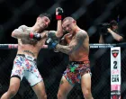 Jul 19, 2025; New Orleans, Louisiana, UNITED STATES; Max Holloway (red gloves) fights against Dustin Poirier (blue gloves) during UFC 318 at Smoothie King Center. Mandatory Credit: Stephen Lew-Imagn Images