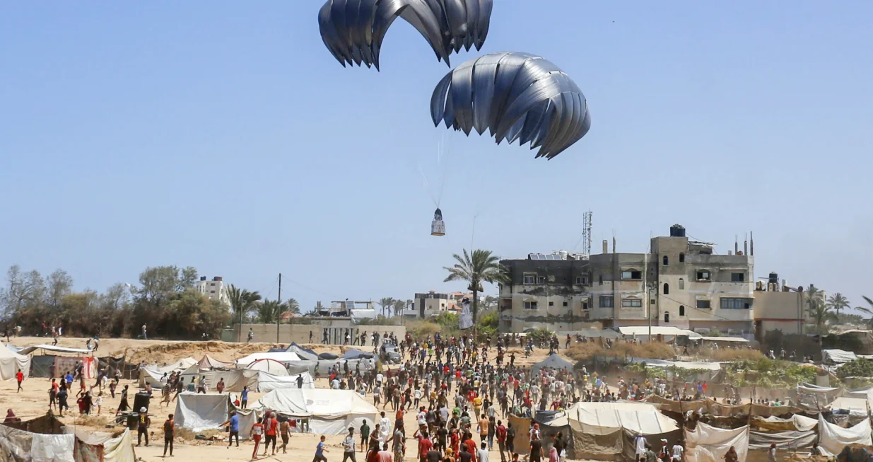 DEIR AL BALAH, GAZA - 4. AUGUST:Avion iz zraka ispušta humanitarnu pomoć padobranom iznad područja Al-Zawaida u Deir al-Balahu, Gaza, 4. augusta 2025. Palestinci se bore da prime pomoć koju ispuštaju vojni teretni avioni. Pokušaji spuštanja humanitarne pomoći padobranom u Pojas Gaze, koji je pod izraelskim napadom i embargom, se nastavljaju. (Mohammed Nassar - Anadolu Agency)/Foto: 