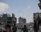 Palestinians look at aid packages that are airdropped over Gaza, in Gaza City, August 8, 2025. REUTERS/Mahmoud Issa/Mahmoud Issa