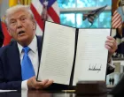 U.S. President Donald Trump displays a signed executive order on gold card visa in the Oval Office at the White House in Washington, D.C., U.S., September 19, 2025. REUTERS/Ken Cedeno  TPX IMAGES OF THE DAY/Ken Cedeno