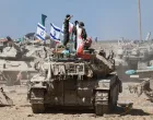 Israeli soldiers stand on a tank near the Israel-Gaza border, in Israel, October 19, 2025. REUTERS/Amir Cohen/Amir Cohen