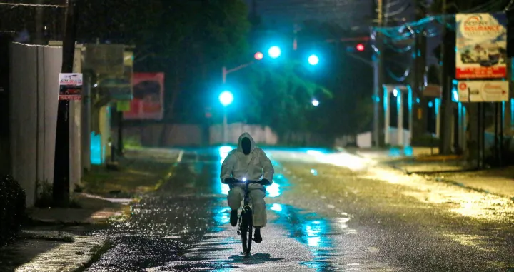 A man wearing a protective suit cycles on a street, as Hurricane Melissa approaches, in Kingston, Jamaica, October 27, 2025. REUTERS/Octavio Jones  TPX IMAGES OF THE DAY/Octavio Jones