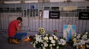A man prays near candles that he lit at the entrance of the Novi Sad railway station, on the first anniversary of the fatal November 2024 canopy collapse of the station, which killed 16 people, triggering nationwide accusations of widespread corruption and negligence, in Novi Sad, Serbia, November 1, 2025. REUTERS/Alkis Konstantinidis/Alkis Konstantinidis