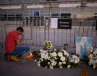 A man prays near candles that he lit at the entrance of the Novi Sad railway station, on the first anniversary of the fatal November 2024 canopy collapse of the station, which killed 16 people, triggering nationwide accusations of widespread corruption and negligence, in Novi Sad, Serbia, November 1, 2025. REUTERS/Alkis Konstantinidis/Alkis Konstantinidis
