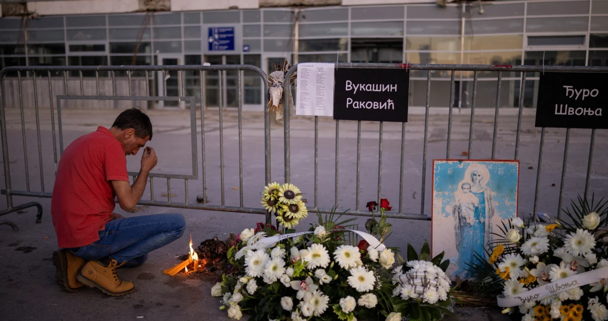 A man prays near candles that he lit at the entrance of the Novi Sad railway station, on the first anniversary of the fatal November 2024 canopy collapse of the station, which killed 16 people, triggering nationwide accusations of widespread corruption and negligence, in Novi Sad, Serbia, November 1, 2025. REUTERS/Alkis Konstantinidis/Alkis Konstantinidis