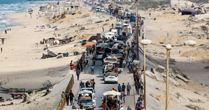 Palestinians, who were displaced to the southern part of Gaza at Israel's order during the war, make their way along a road as they return to the north, amid a ceasefire between Israel and Hamas in Gaza, in the central Gaza Strip, October 12, 2025. REUTERS/Mahmoud Issa/Mahmoud Issa