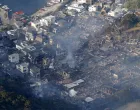 Smoke rises from a site where a massive fire blazed through more than 170 buildings, as seen from a helicopter, in Oita, Oita Prefecture, southwestern Japan, November 19, 2025, in this photo taken by Kyodo. Mandatory credit Kyodo/via REUTERS ATTENTION EDITORS - THIS IMAGE HAS BEEN SUPPLIED BY A THIRD PARTY. MANDATORY CREDIT. JAPAN OUT. NO COMMERCIAL OR EDITORIAL SALES IN JAPAN./Kyodo