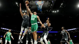 Nov 18, 2025; Brooklyn, New York, USA; Boston Celtics center Luka Garza (52) fights for a rebound against Brooklyn Nets forward Michael Porter Jr. (17) and guard Terance Mann (14) and center Nic Claxton (33) during the first quarter at Barclays Center. Mandatory Credit: Brad Penner-Imagn Images/Foto: Brad Penner