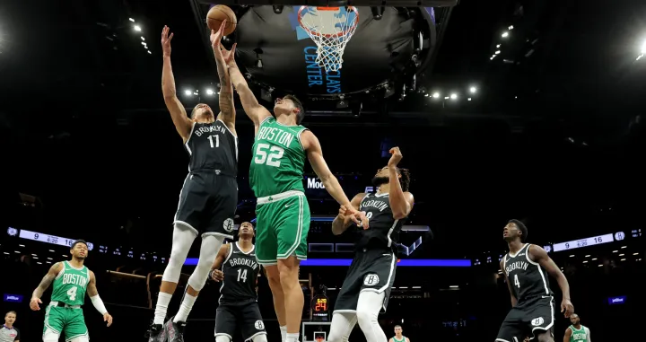 Nov 18, 2025; Brooklyn, New York, USA; Boston Celtics center Luka Garza (52) fights for a rebound against Brooklyn Nets forward Michael Porter Jr. (17) and guard Terance Mann (14) and center Nic Claxton (33) during the first quarter at Barclays Center. Mandatory Credit: Brad Penner-Imagn Images/Foto: Brad Penner