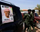FILE PHOTO: Soldiers walk near a campaign poster of Guinea-Bissau's incumbent President Umaro Sissoco Embalo, ahead of the presidential election scheduled for November 23, in Bissau, Guinea-Bissau November 20, 2025. REUTERS/Luc Gnago/File Photo/Luc Gnago