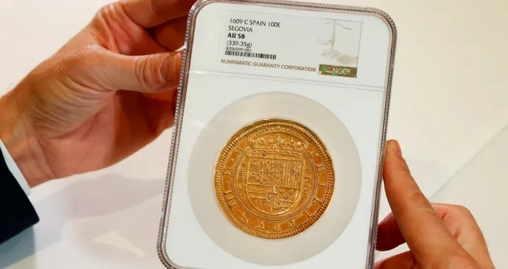 Frank Baldacci, chairman and CEO of Numismatica Genevensis auction house, holds the Segovian Centen, the first 100-escudo coin weighing 339.35 grams of gold, struck by King Philip III in 1609, during a preview ahead of its sale starting at 2,000,000 Swiss francs (,478,000 USD) in Geneva, Switzerland, November 24, 2025. REUTERS/Denis Balibouse/Denis Balibouse