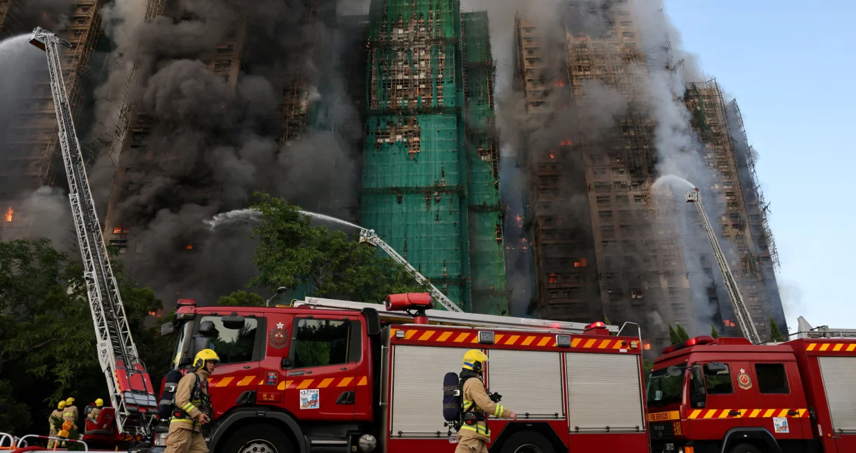 Firefighters work as efforts are underway to extinguish flames engulfing bamboo scaffolding across multiple buildings at the Wang Fuk Court housing estate in Tai Po, Hong Kong, China, November 26, 2025. REUTERS/Tyrone Siu  TPX IMAGES OF THE DAY/Tyrone Siu